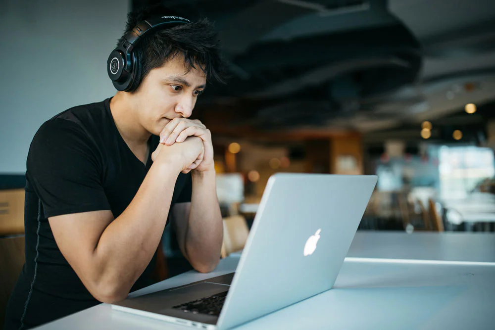 man working on laptop with headphonesr