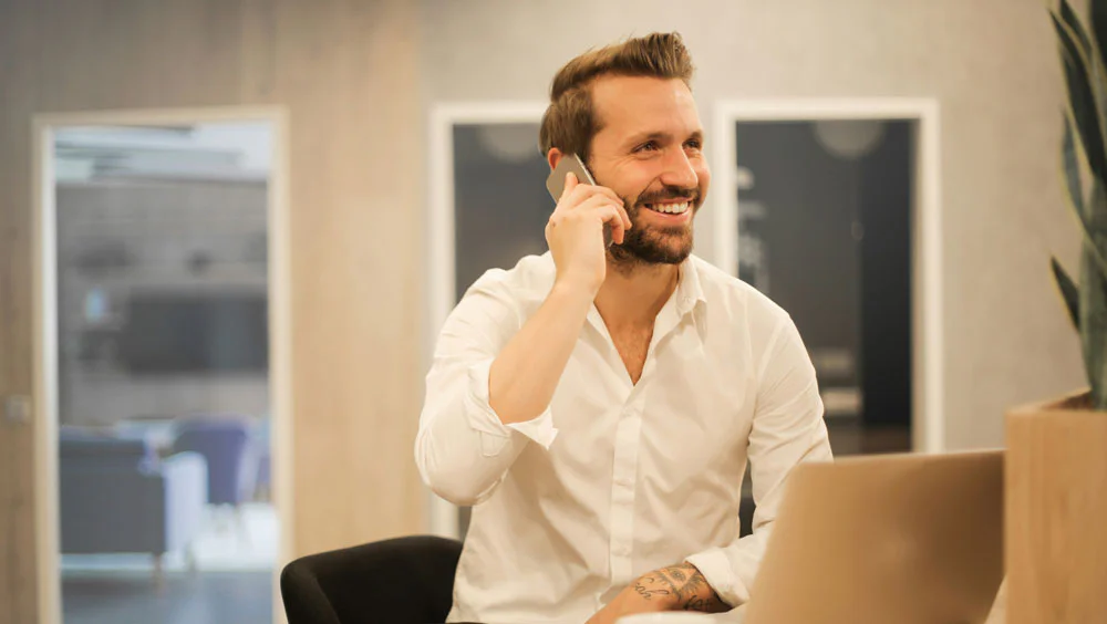 man on phone in front of computer
